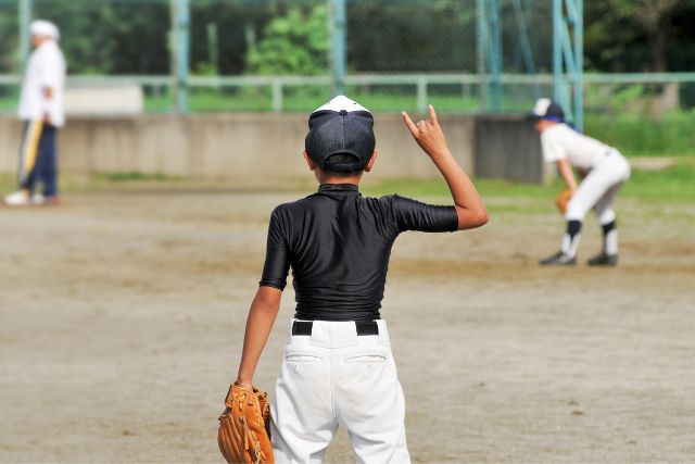 ツーアウトのサインをする男の子