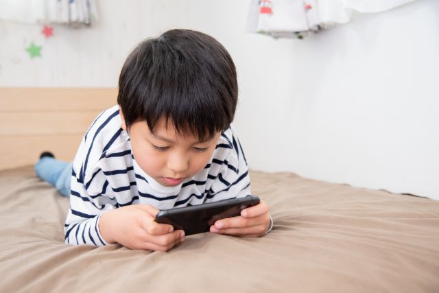 ベッドでゲームをしている男の子