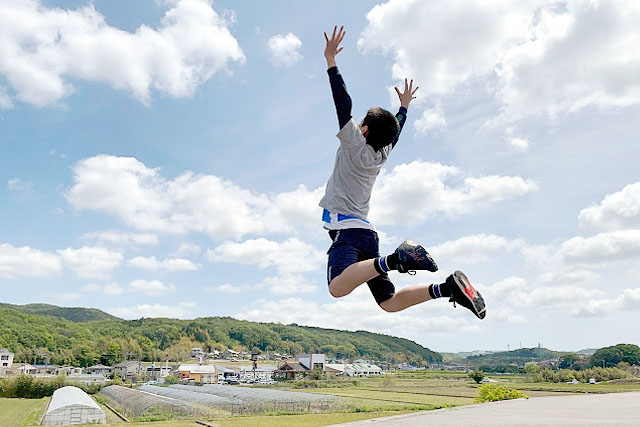 空に向かってジャンプする男の子