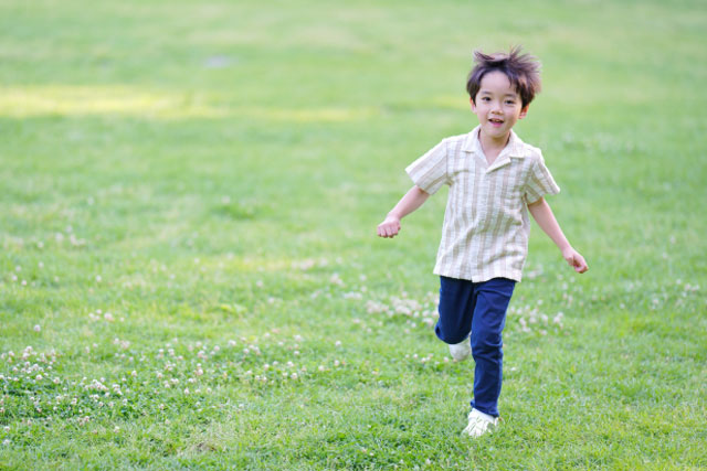 原っぱを走っている男の子