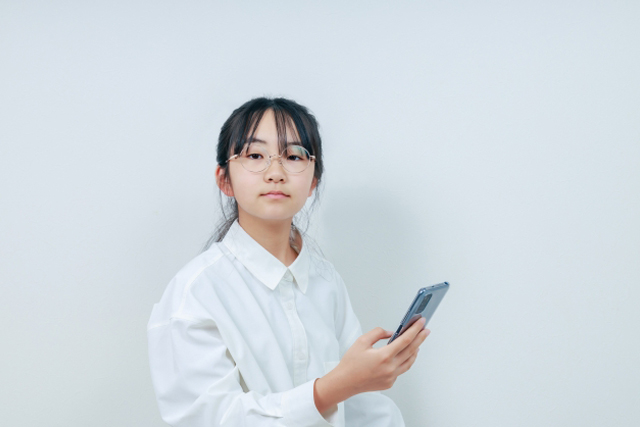 スマホを持っている眼鏡の女の子