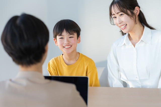 先生と話している男の子と母親