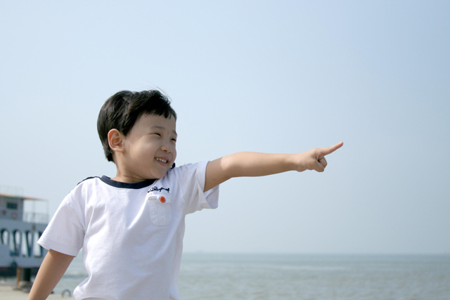 遠くに向かって指を指している男の子