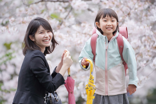 傘を持っている母親とサンドセルを背負った娘